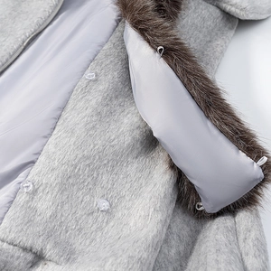 Detail of grey woolen jacket with brown faux fur hood trim and smooth inner lining