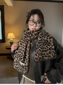 Detail of soft leopard print wool-like scarf with a small design label for winter style