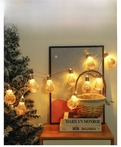 Detail of warm white LED copper wire string lights inside retro glass bulbs for Christmas