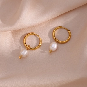 Detail of 18K gold hoop earrings with freshwater pearls on a pink silk background
