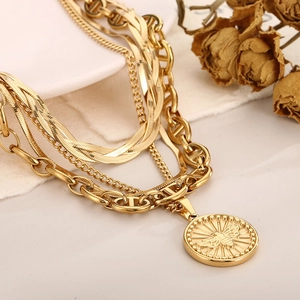 Detail of gold layered titanium steel necklace with a honeybee coin pendant and mariner links