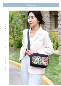 Crossbody oxford bag with floral prints shown on a model in a natural outdoor park setting