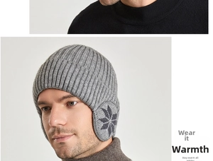 Detail van donkergrijze gebreide muts met oorkleppen en jacquardpatroon met sneeuwvlokken