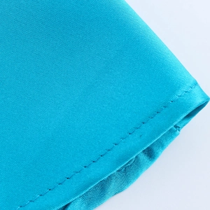 Detail of blue satin slip dress fabric showing high-quality stitching and smooth texture