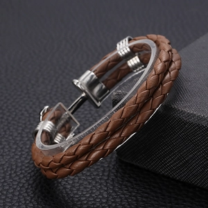 Detail of brown braided leather bracelet with silver anchor buckle on display stand
