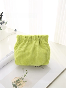 Detail view of the soft corduroy texture and drawstring closure on a mini makeup bag