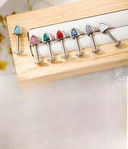 Macro detail of F136 titanium alloy cat ear studs with colorful zircon inlays