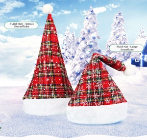 Detail of red plaid Christmas hats with white snowflake patterns and plush trim in a snowy scene