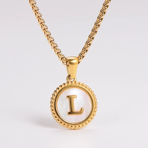 Detailed view of golden necklace with a white shell pendant and a central letter L