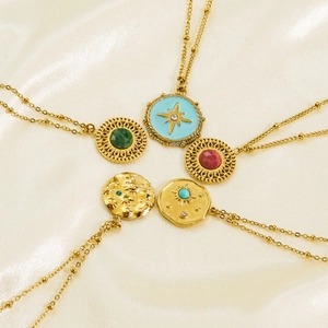 Detail of 18K gold-plated bohemian necklaces featuring enamel stars and colorful gemstones