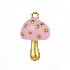 Macro shot of pink enamel mushroom pendant with gold dots and metal hanging loop