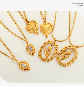 Détail des pendentifs tulipe et cœur dorés avec zircons sur chaînes élégantes