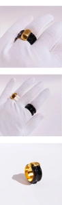 Detail of wide black and white enamel rings with gold ridge texture in close-up