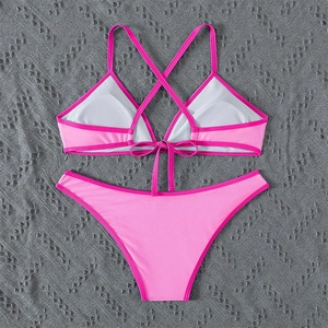 Detail of pink two-piece bikini featuring contrast trim and cross tie-up straps design