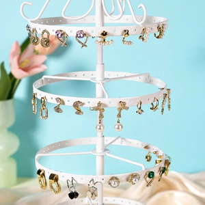 White multi-layer metal earring display stand with adjustable tiers and jewelry items