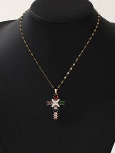 Detail of cross pendant with multi-colored zircons on a gold chain worn on model