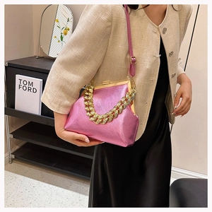 Detail of pink metallic leather handbag featuring bold gold chain and vintage clip closure