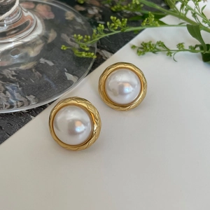 Elegant 925 silver pearl stud earrings with quilted gold base on a white background