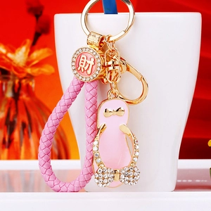 Detail of pink rhinestone flip-flop keychain with gold lucky coin charm on ceramic cup