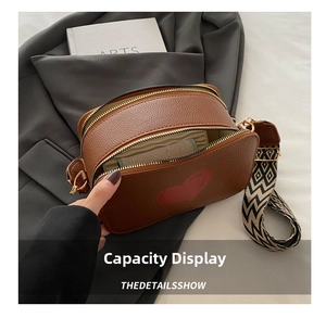 Detailed view of the brown camera bag's interior capacity with its woven strap
