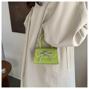 Detalle del mini bolso bandolera verde lima con lazo de diamantes de imitación y cadena de plata