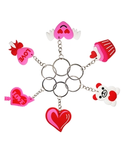 Flat lay of pink and red PVC heart keychains with cute bear and cupcake pendants