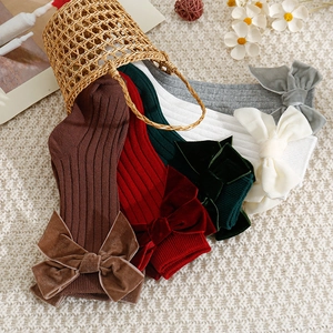 Spanish style ribbed knit baby socks with velvet bows in neutral and festive colors