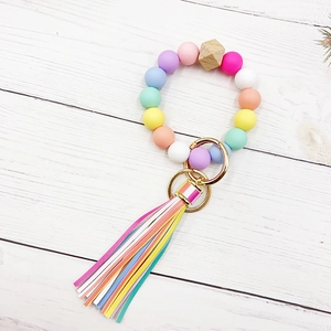 Detail of colorful silicone bead keychain with macrame tassel and natural wood hex bead