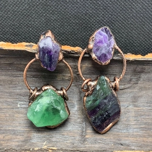 Detalle de pendientes hechos a mano de amatista y fluorita en bruto con borde de bronce galvanizado