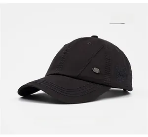 Detail of dark grey cotton baseball cap featuring side embroidery and metal emblem