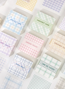 Macro shot of grid pattern sticky notes in pastel blue, pink, and green colors
