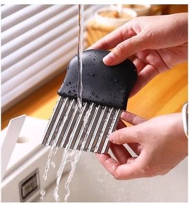 Detailed view of washing a stainless steel crinkle cutter with water for easy cleaning