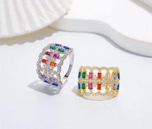 Detailed macro of hollowed-out 925 silver and 18k gold rings with rainbow gemstones