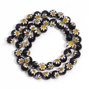 Macro shot of spiral-arranged black Millefiori glass beads with floral patterns
