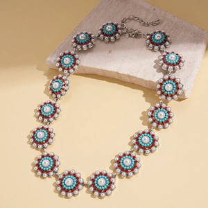 Detail of vintage sun flower necklace with turquoise beads and faux pearls on stone