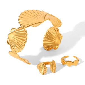 Golden seashell jewelry set featuring a wide open cuff bracelet and matching shell rings