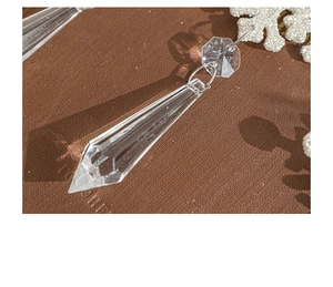 Close-up of clear acrylic crystal pendant with sharp multifaceted prism cutting and metal ring