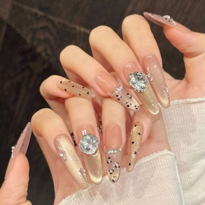 Détails macro de faux ongles stiletto longs avec motif léopard et paillettes œil de chat
