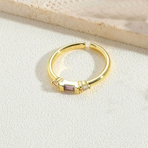 Close-up of golden adjustable ring with purple rectangular zircon and crystal details