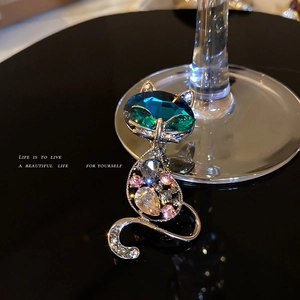 Elegant silver-toned cat brooch featuring colorful marquise crystals on black background