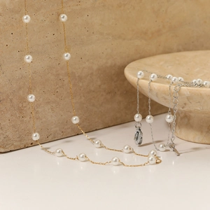 Elegant gold and silver pearl necklaces displayed on a luxury stone base for women
