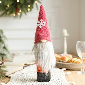 Christmas gnome wine bottle cover with red felt hat and white snowflake decoration