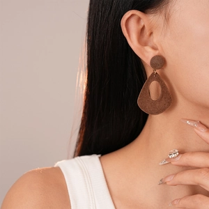 Vue détaillée de grandes boucles d'oreilles gouttes marron floquées sur un mannequin