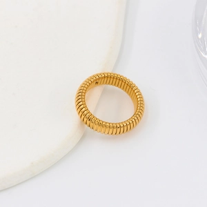 Detailed macro view of a gold gaspipe style spiral ring with industrial textured finish
