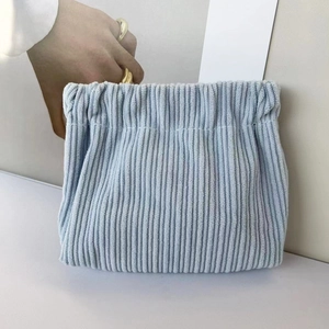 Detail view of a light blue corduroy pouch showing the textured fabric and drawstring closure