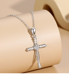 Macro detail of s925 silver cross pendant with pavé cubic zirconia and heart center