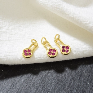 Macro view of gold rectangular charms with pink zircon flower inlay for DIY jewelry