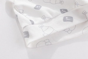 Macro shot of newborn cotton baby hat showing ribbed knit texture and cool cartoon print