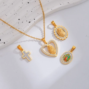 Golden religious pendants with cross, heart, and Virgin Mary motifs on white stone
