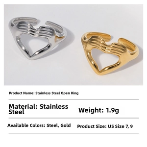 Detail of stainless steel open rings with creative heart-shaped hands design in gold and steel